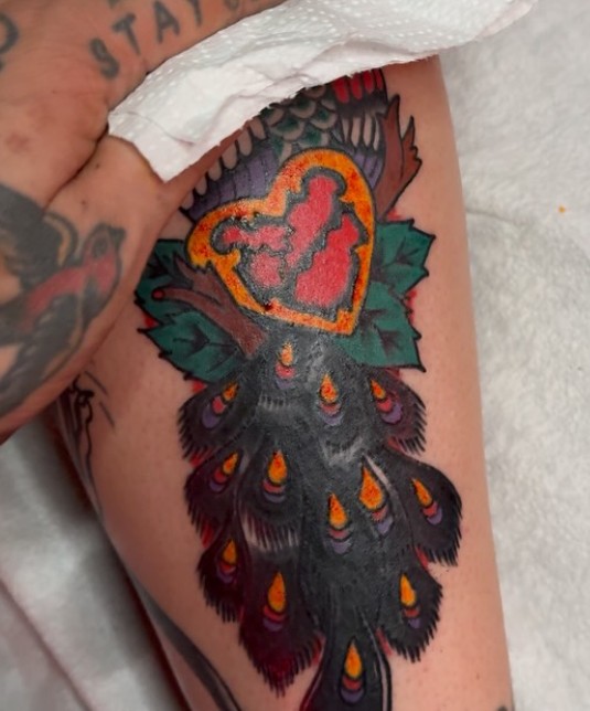 Sacred heart with peacock feathers tattoo